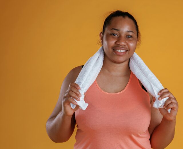 photo of a women in workout gear holding a towel