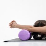 photo of a woman stretching using a foam roller