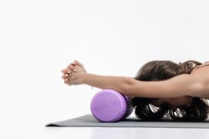photo of a woman stretching using a foam roller