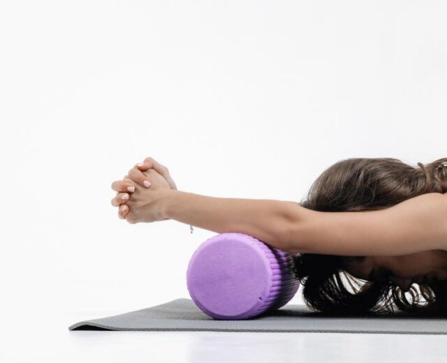 photo of a woman stretching using a foam roller