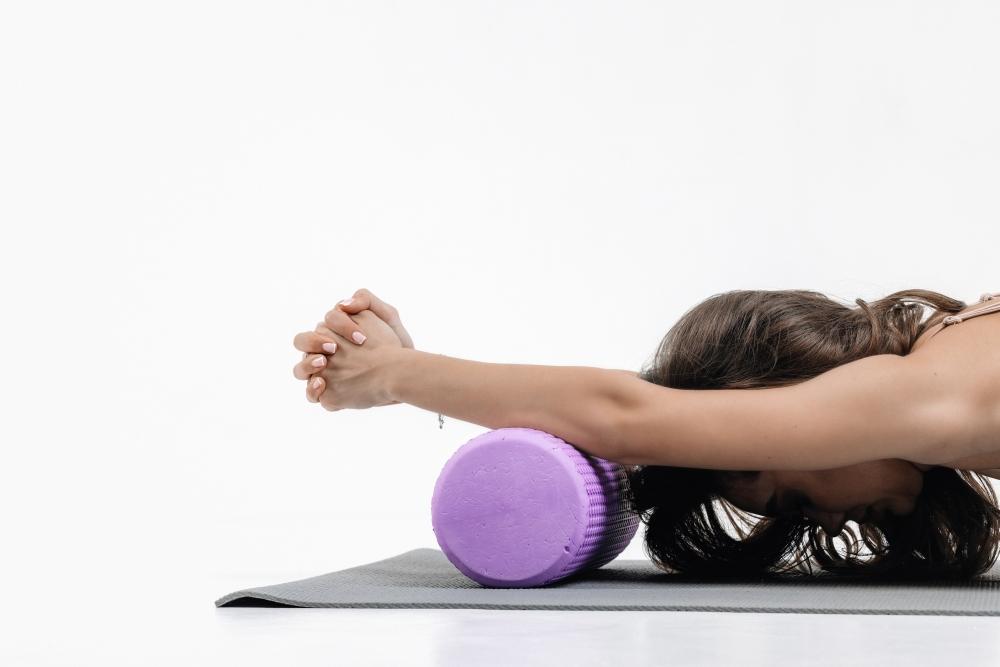 photo of a woman stretching using a foam roller