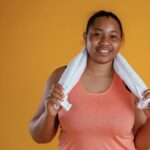 photo of a women in workout gear holding a towel