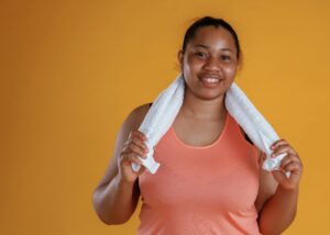 photo of a women in workout gear holding a towel
