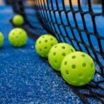 photo of pickleballs next to a net
