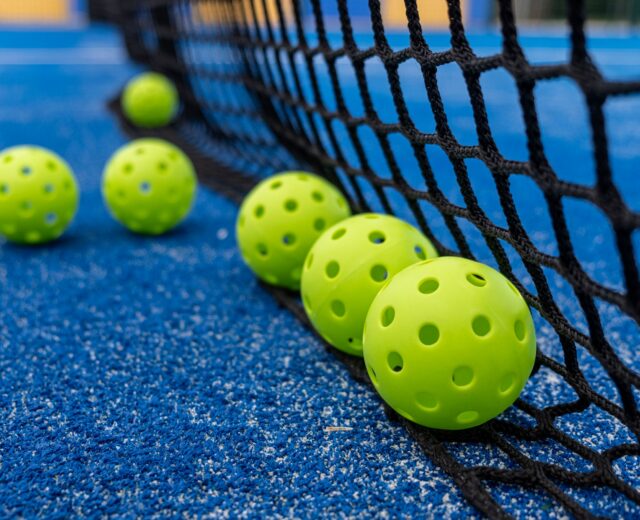 photo of pickleballs next to a net