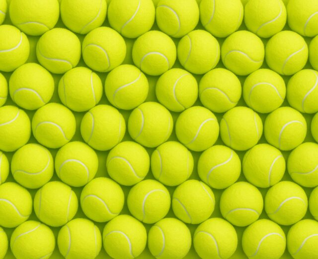 photo of a wall of tennis balls