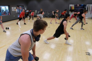 photo of a group fitness class where participants and using free wights